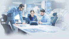 Meeting in a conference room image: Meeting in a conference room, all three people looking at an ipad.