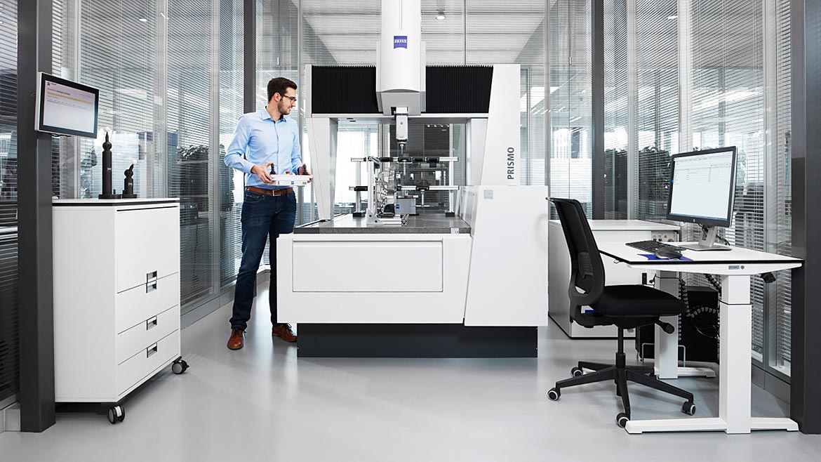 Businessman in office with ZEISS CONNECTED QUALITY software and equipment.