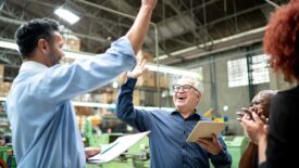 Coworkers celebrating some good news in a factory.